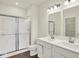 This bathroom features double sinks, white cabinets, a shower, and modern lighting fixtures at 2021 Frost Line Ln, Greenfield, IN 93927