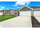 The home features a two-car garage and a well-manicured lawn under a vibrant blue sky at 2021 Frost Line Ln, Greenfield, IN 93927