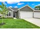 Charming home with gray siding, a two-car garage, and a well-manicured lawn under a blue sky at 2021 Frost Line Ln, Greenfield, IN 93927
