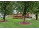 Expansive backyard featuring a brick house with a wooden deck, mature trees, and lush green lawn at 230 Love Ave, Greenwood, IN 46142