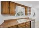 Classic kitchen sink with wood cabinets and a window overlooking the backyard at 230 Love Ave, Greenwood, IN 46142