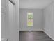 Bright bedroom features a window view and modern, neutral tones and stylish gray woodgrain flooring at 26098 Six Points Rd, Sheridan, IN 46069