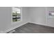 Sunlit bedroom highlighting sleek gray floors, white trim, and view of the front yard through a large window at 26098 Six Points Rd, Sheridan, IN 46069