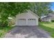 A detached two-car garage with white doors and an asphalt driveway offers convenient parking at 26098 Six Points Rd, Sheridan, IN 46069