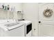 Functional laundry room with modern white washer and dryer, storage shelving, and decorative wreath at 2612 Ruffian Dr, Westfield, IN 46074