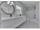Modern bathroom with double sink vanity, round mirror, patterned floors and tub with shower at 2860 Winthrop Ave, Indianapolis, IN 46205
