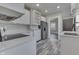 This kitchen features stainless steel appliances, sleek white cabinetry, and stylish gray flooring at 2860 Winthrop Ave, Indianapolis, IN 46205