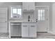 Bright kitchen features a stainless steel dishwasher, white cabinets, and a window above the sink at 2860 Winthrop Ave, Indianapolis, IN 46205