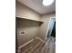 Neutral laundry room with wood-look floors, utility connections, shelf and a view to another room at 2951 S Elizabeth St, Indianapolis, IN 46203