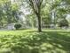 Expansive backyard featuring mature trees and green lawn, perfect for outdoor activities at 343 E Waterbury Rd, Indianapolis, IN 46227