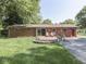 Brick home featuring a wood deck, patio, and spacious yard at 343 E Waterbury Rd, Indianapolis, IN 46227