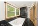 Bathroom with a large soaking tub and stylish black tile accents at 3545 Whippoorwill Lake N Dr, Monrovia, IN 46157