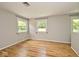 Bedroom with hardwood floors, neutral paint, and well-lit with three large windows at 3545 Whippoorwill Lake N Dr, Monrovia, IN 46157