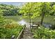 Charming wooden stairs leading to a tranquil lake dock with a built-in bench at 3545 Whippoorwill Lake N Dr, Monrovia, IN 46157