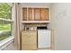 Laundry room with oak cabinets above washer and dryer with window to outdoors at 3545 Whippoorwill Lake N Dr, Monrovia, IN 46157