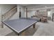 Finished basement with ping pong table, seating area, and wooden staircase at 4084 Mountbatton Dr, Greenwood, IN 46143