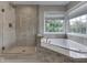 Bathroom featuring tiled walk-in shower, soaking tub, and large window overlooking the backyard at 4084 Mountbatton Dr, Greenwood, IN 46143
