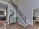 Staircase and foyer feature a modern railing and sightlines into the kitchen and living room at 4084 Mountbatton Dr, Greenwood, IN 46143