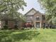 Charming brick home with a manicured lawn, mature trees, and attractive landscaping at 4084 Mountbatton Dr, Greenwood, IN 46143