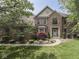 Charming brick home with a manicured lawn, mature trees, and attractive landscaping at 4084 Mountbatton Dr, Greenwood, IN 46143