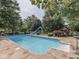A sparkling pool and backyard featuring mature landscaping and a fun slide at 4084 Mountbatton Dr, Greenwood, IN 46143