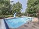 Backyard featuring a sparkling pool, mature landscaping, and a slide for summer fun at 4084 Mountbatton Dr, Greenwood, IN 46143