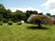 Expansive lawn with ornamental trees and greenery offer a tranquil, park-like setting at 413 Blue Spring Dr, Indianapolis, IN 46239