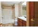 Well-lit bathroom with white tub/shower, wood vanity, and tile flooring for a clean and functional space at 413 Blue Spring Dr, Indianapolis, IN 46239