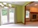 Bright dining room featuring French doors, patterned curtains, and a glimpse into the living room with a brick fireplace at 413 Blue Spring Dr, Indianapolis, IN 46239