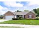 Charming brick home featuring manicured landscaping, an attached garage and tasteful maroon window shutters at 413 Blue Spring Dr, Indianapolis, IN 46239