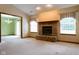 Inviting living room featuring a classic brick fireplace, neutral carpeting, and abundant natural light at 413 Blue Spring Dr, Indianapolis, IN 46239