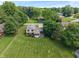 Expansive lawn surrounds this two-story home with a screened-in porch and mature trees, offering privacy and charm at 4155 Rolling Trails Rd, Greenwood, IN 46142