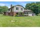 Spacious backyard with lush green lawn, mature trees, and a well-manicured garden at 4155 Rolling Trails Rd, Greenwood, IN 46142