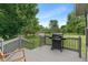 Deck with grill overlooks lush backyard, complete with storage shed, mature trees, and playset at 4155 Rolling Trails Rd, Greenwood, IN 46142