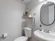 Clean half bathroom with modern fixtures, floating shelves, and a stylish oval mirror at 4155 Rolling Trails Rd, Greenwood, IN 46142