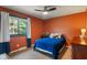 Inviting bedroom featuring warm orange walls, a window view, and a comfortable blue bed at 4155 Rolling Trails Rd, Greenwood, IN 46142