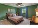 Comfortable bedroom with green walls, a ceiling fan, and a window with green views at 4155 Rolling Trails Rd, Greenwood, IN 46142