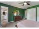 Cozy bedroom showcasing stylish decor, green walls, a wooden dresser and a connecting bathroom at 4155 Rolling Trails Rd, Greenwood, IN 46142