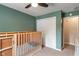Bright bedroom featuring warm green walls, a closet, and a modern baby crib at 4155 Rolling Trails Rd, Greenwood, IN 46142