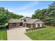 Charming brick home with attached garage, lush landscaping, and a long driveway leading to the front entrance at 4155 Rolling Trails Rd, Greenwood, IN 46142