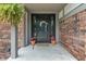 Inviting front entrance features a modern black door, potted plants, and brick facade at 4155 Rolling Trails Rd, Greenwood, IN 46142