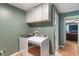 Bright laundry room with modern washer and dryer, white cabinets, and wood-look flooring at 4155 Rolling Trails Rd, Greenwood, IN 46142