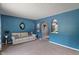 Cozy living room with blue accent wall, neutral carpet, and stylish decorative arched openings at 4155 Rolling Trails Rd, Greenwood, IN 46142