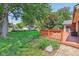 Landscaped backyard featuring a wooden deck and large green lawn and mature trees at 430 Oakbrook Dr, Columbus, IN 47201
