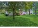 Lush backyard with green lawn and mature trees at 430 Oakbrook Dr, Columbus, IN 47201