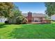 Backyard with large lawn, shrubs, trees, and wooden deck for entertaining at 430 Oakbrook Dr, Columbus, IN 47201