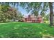 View of the home's backyard with a wooden deck and green lawn at 430 Oakbrook Dr, Columbus, IN 47201