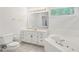 All-white bathroom featuring a marble countertop vanity and soaking tub with tiled backsplash at 430 Oakbrook Dr, Columbus, IN 47201