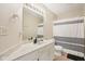Clean bathroom featuring a marble-look vanity, neutral walls, and a shower with striped curtain at 430 Oakbrook Dr, Columbus, IN 47201
