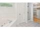 Bright bathroom features a walk-in closet, shower, and soaking tub beneath a window at 430 Oakbrook Dr, Columbus, IN 47201